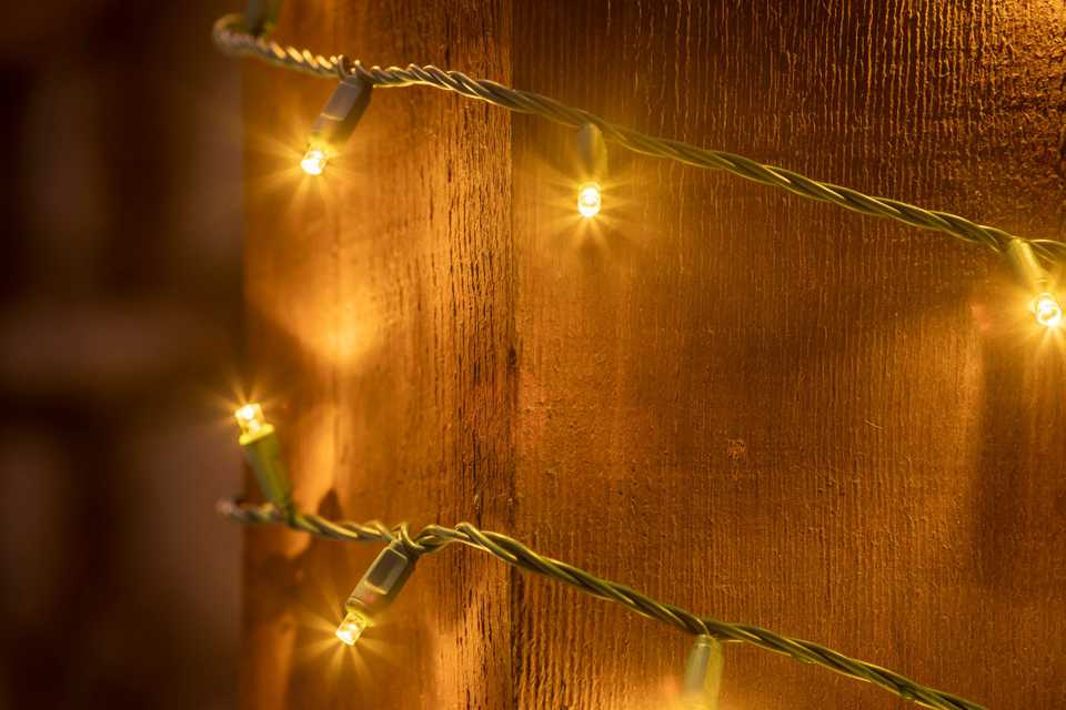 led Christmas light bulbs wrapped around a wooden post