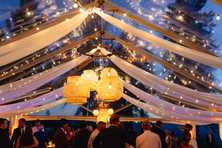 rattan lanterns and drapery in a clear wedding tent