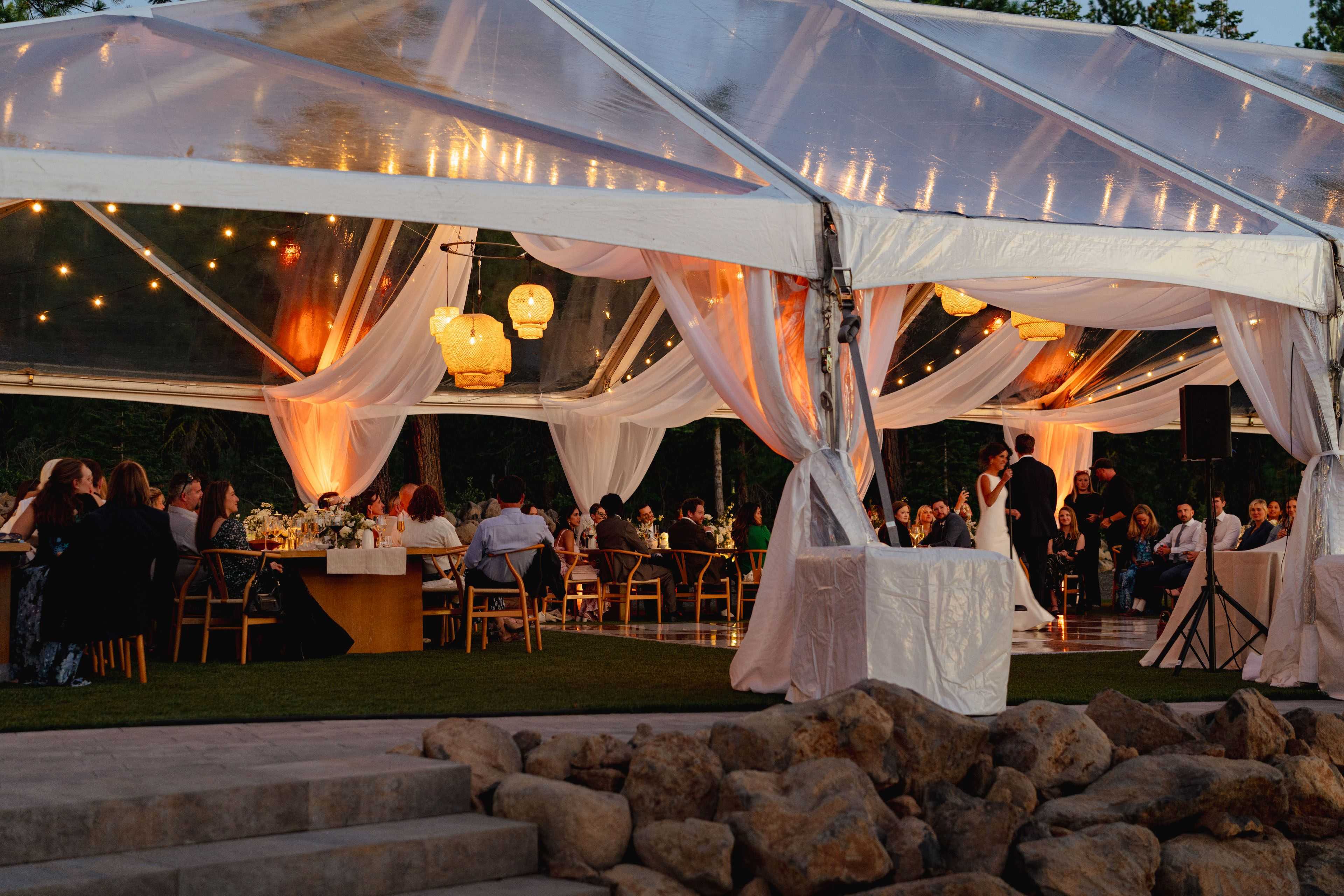 couple having a first dance below a wedding tent with drapery