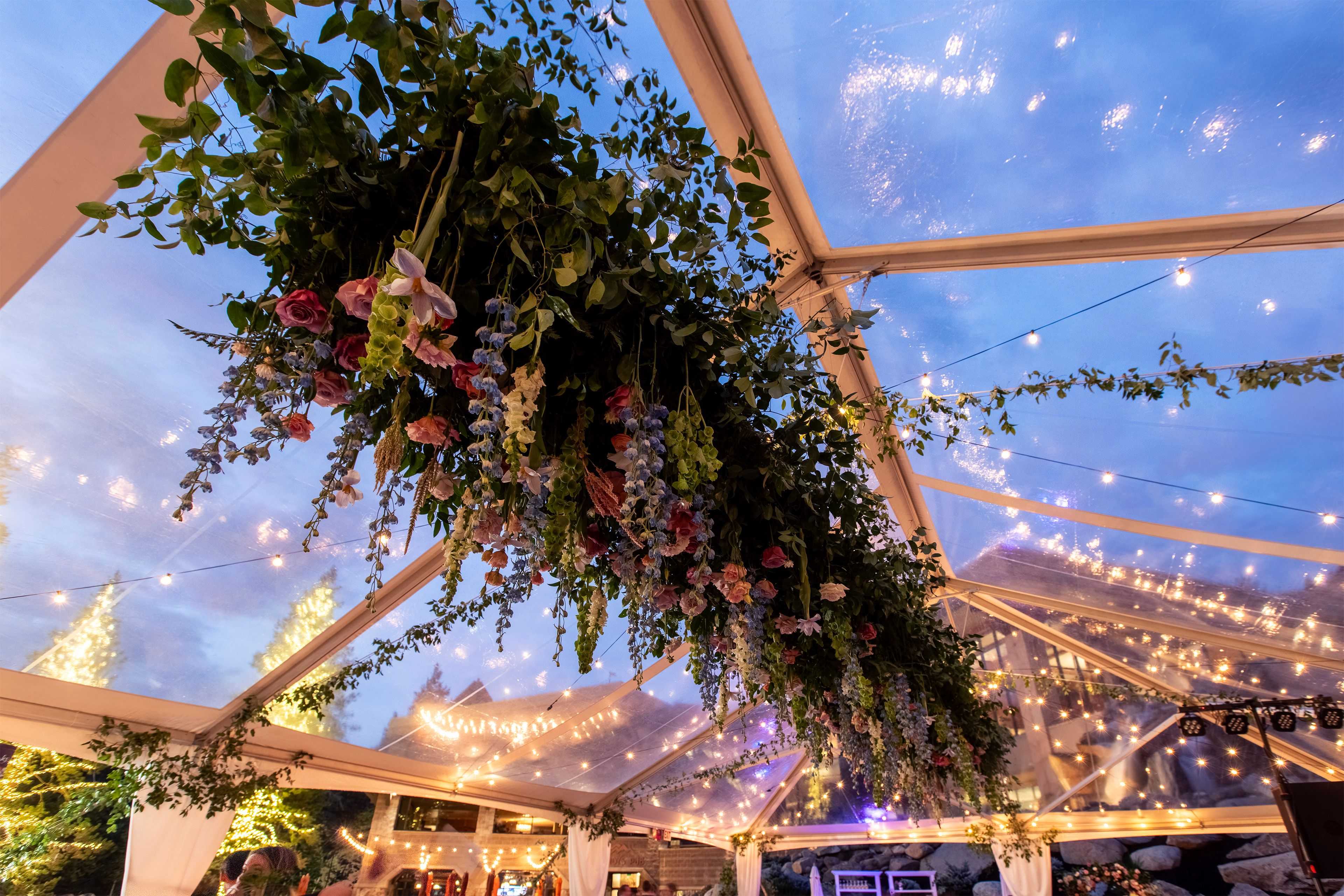 a large floral display hung from the a clear tent