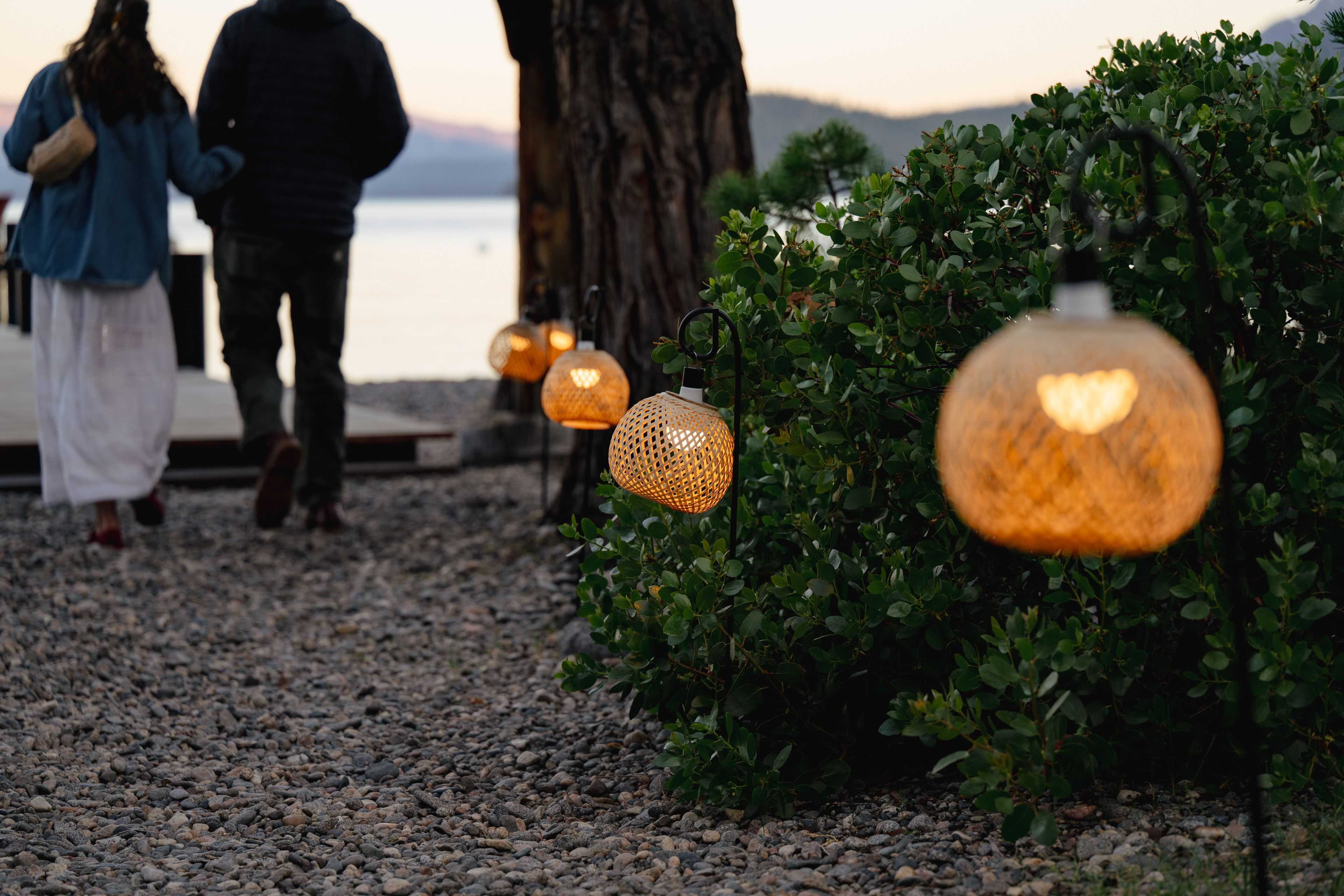mini rattan lanterns lining a pathway to Lake Tahoe