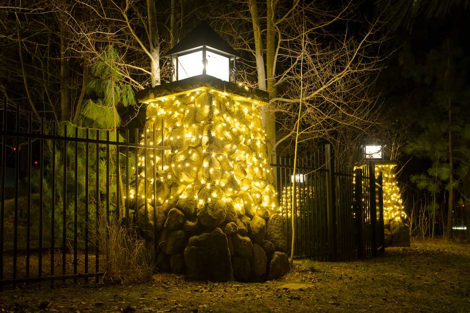 warm white Christmas lighting wrapping a stone pillar monument