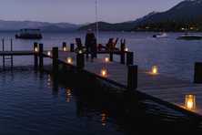 a tahoe pier lined with glass lanterns containing flameless candles