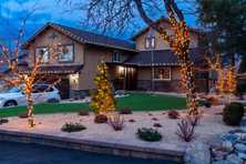 a classic Reno home thoughtfully wrapped in holiday lights including trees in the front yard