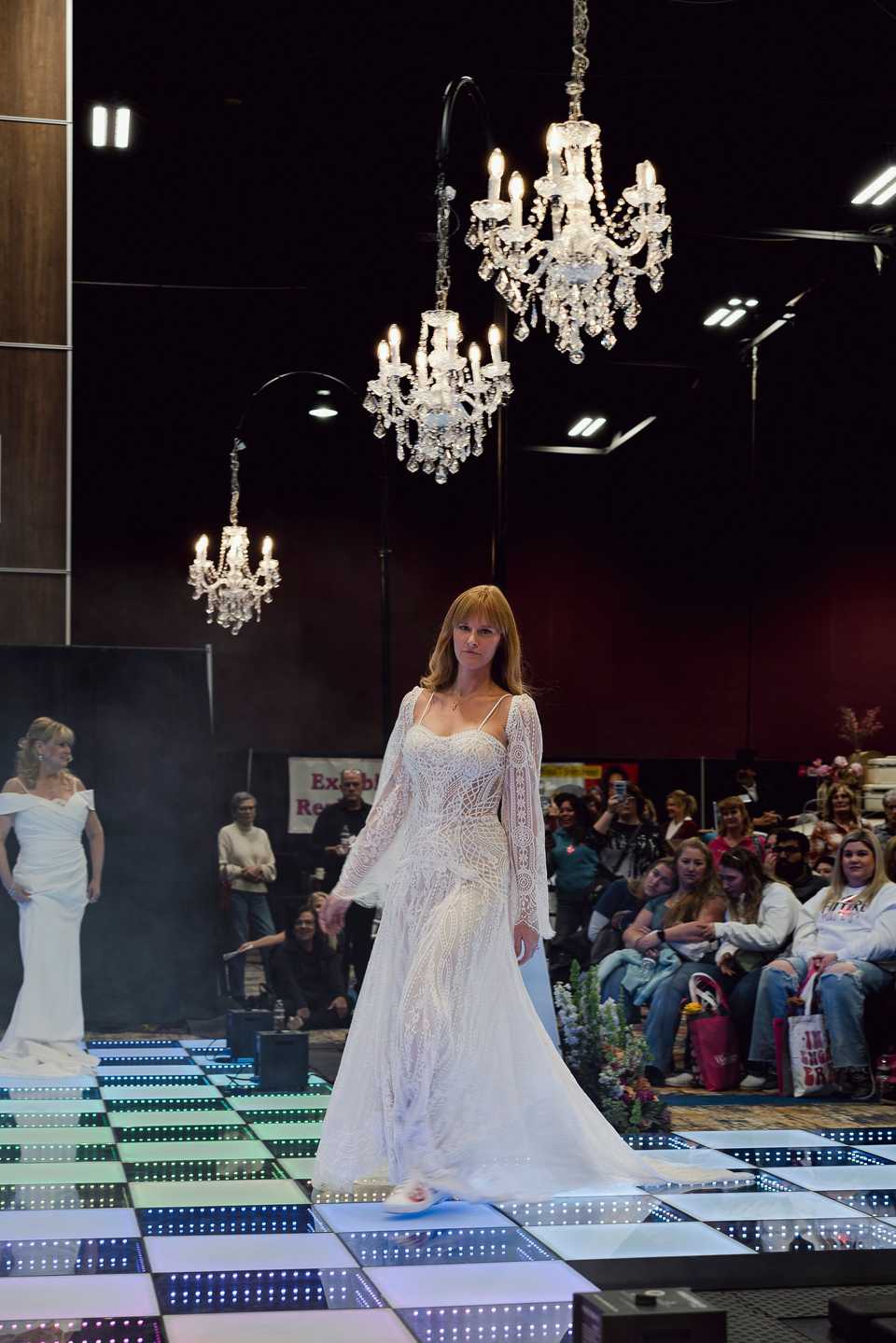 showcase bride walking under chandeliers
