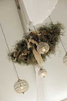 hanging chandeliers and floral from a white wedding tent