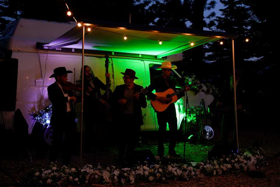 musicians playing in front of a van with colored uplighting