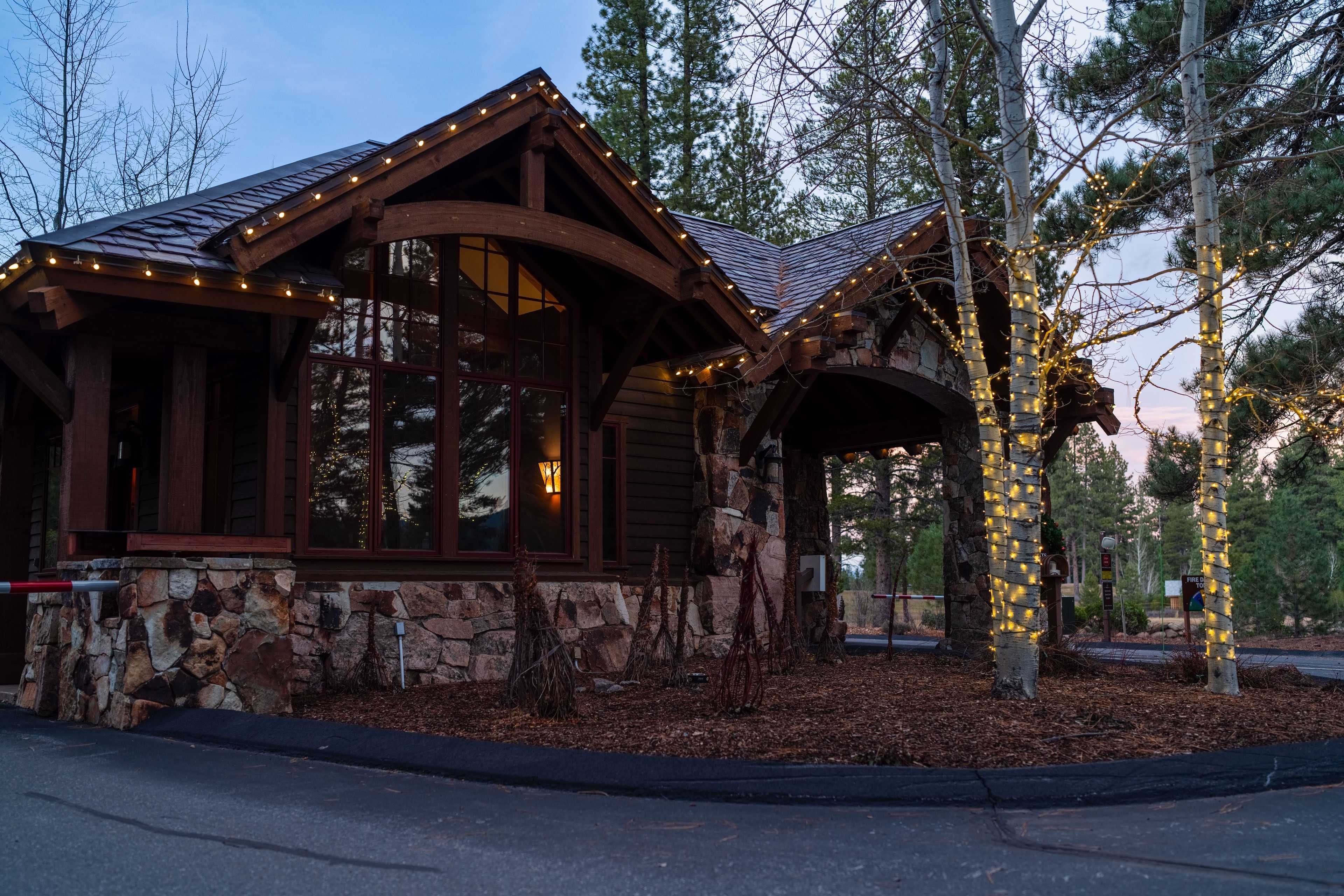 gate house at Schaffer's Mill with holiday lights on the roofline and trees