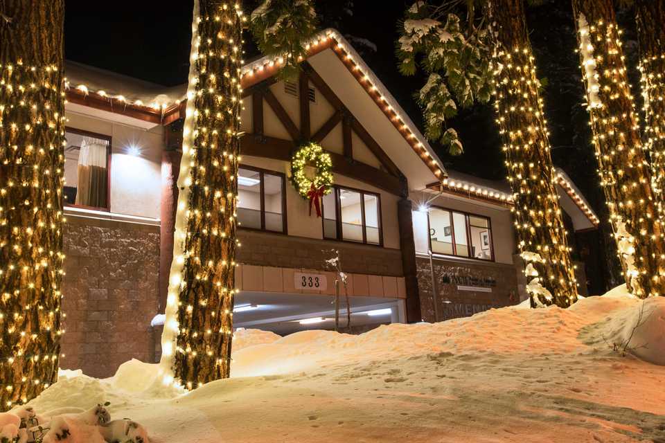 Christmas lights on a building and tree trunks in incline village Nevada