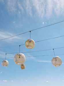 rattan lanterns hanging in a california blue sky