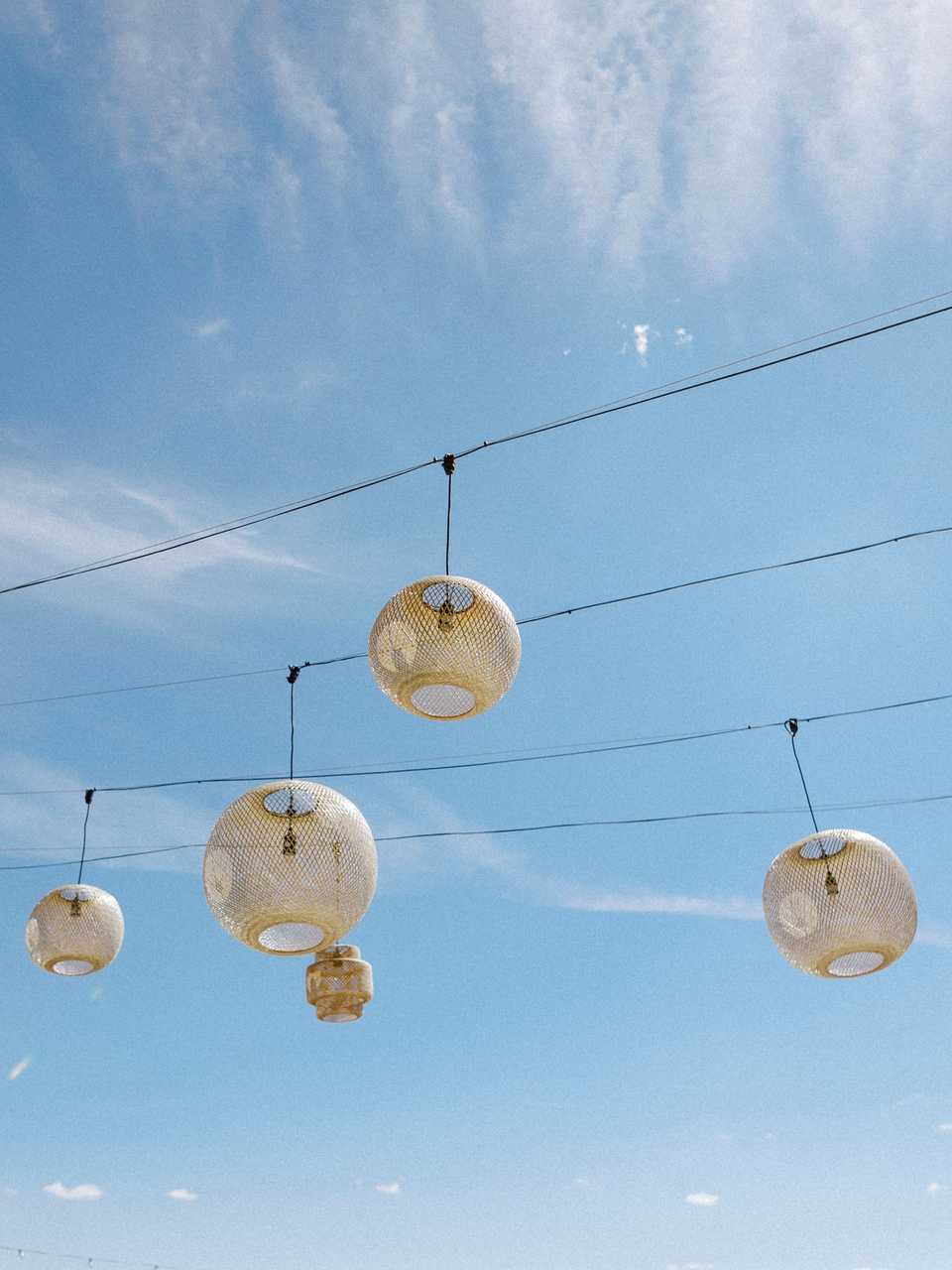 rattan lanterns hanging in a california blue sky