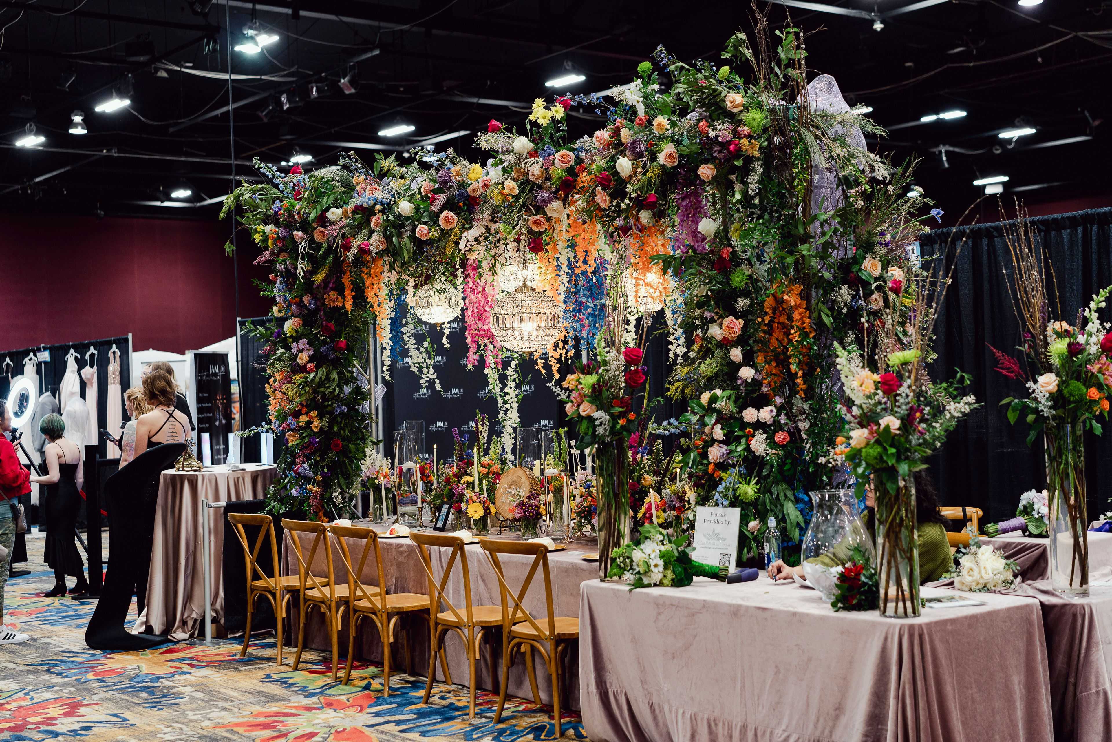 an archway over a table with flowers and chandeliers