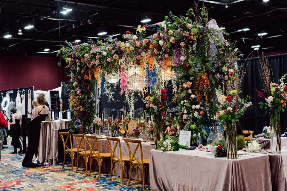 an archway over a table with flowers and chandeliers