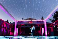 a wedding couple on a dance floor with an led canopy and a truss rigging around at dusk