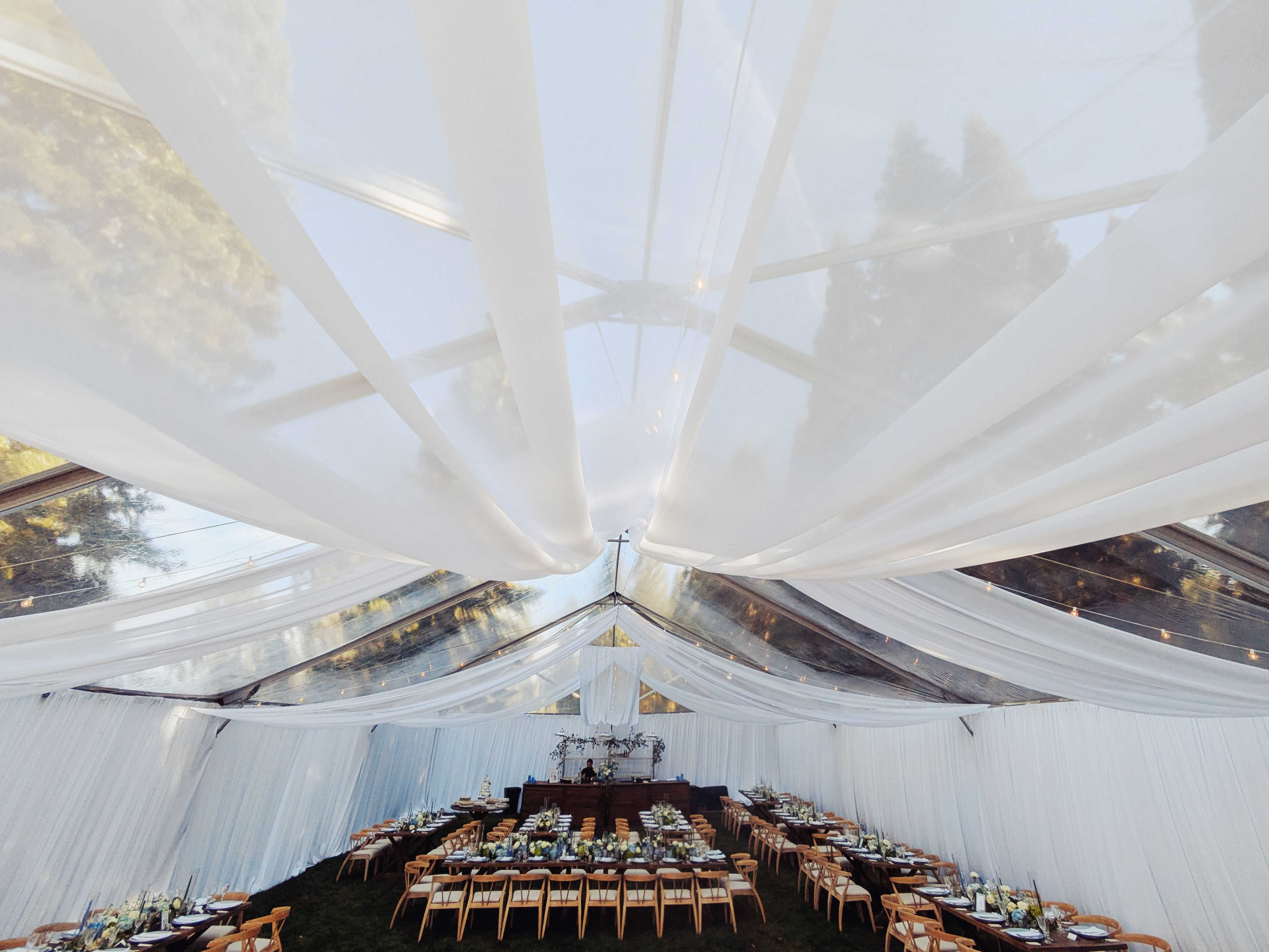 wedding drapery hanging from a clear tent